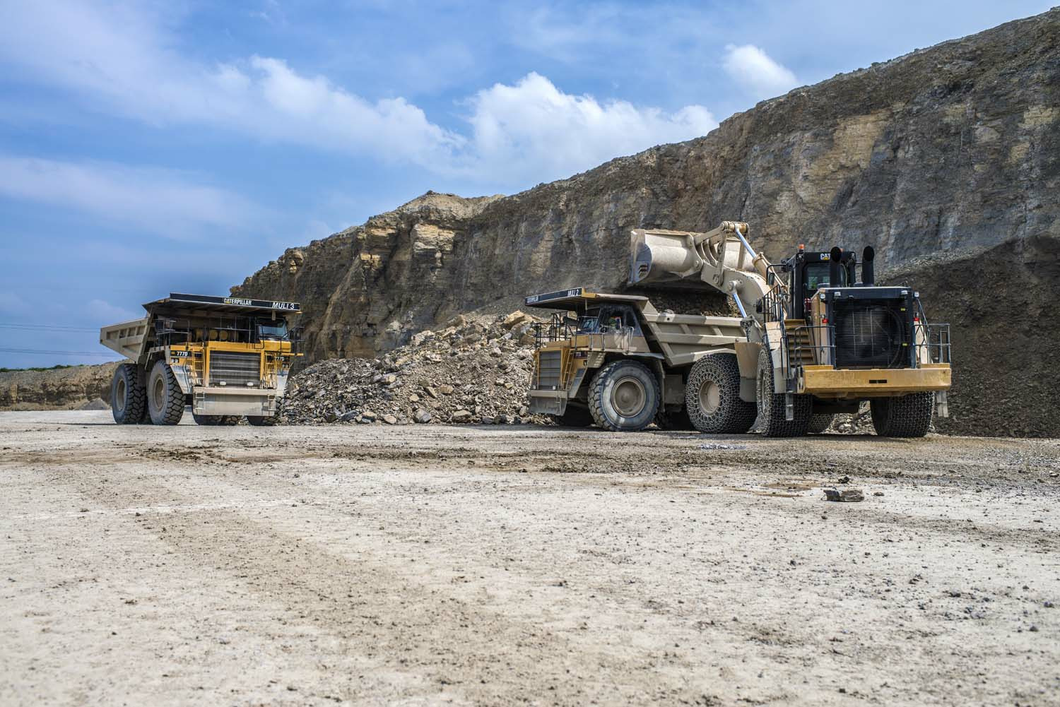 Radlader und Muldenkipper transportieren die Rohmaterialien zu den Brecheranlagen.