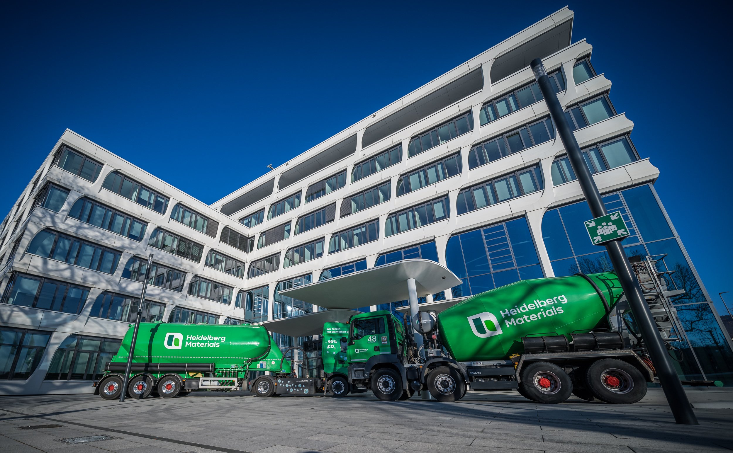 Modernes Bürogebäude, davor stehen Fahrmischer mit der Beschriftung Heidelberg Materials