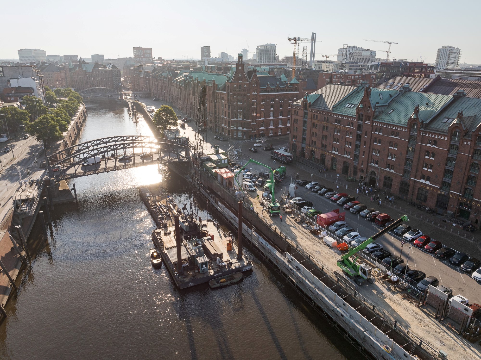 Luftaufnahme einer Baustelle in der Hamburger Speicherstadt mit umliegenden historischen Gebäuden und Kränen.