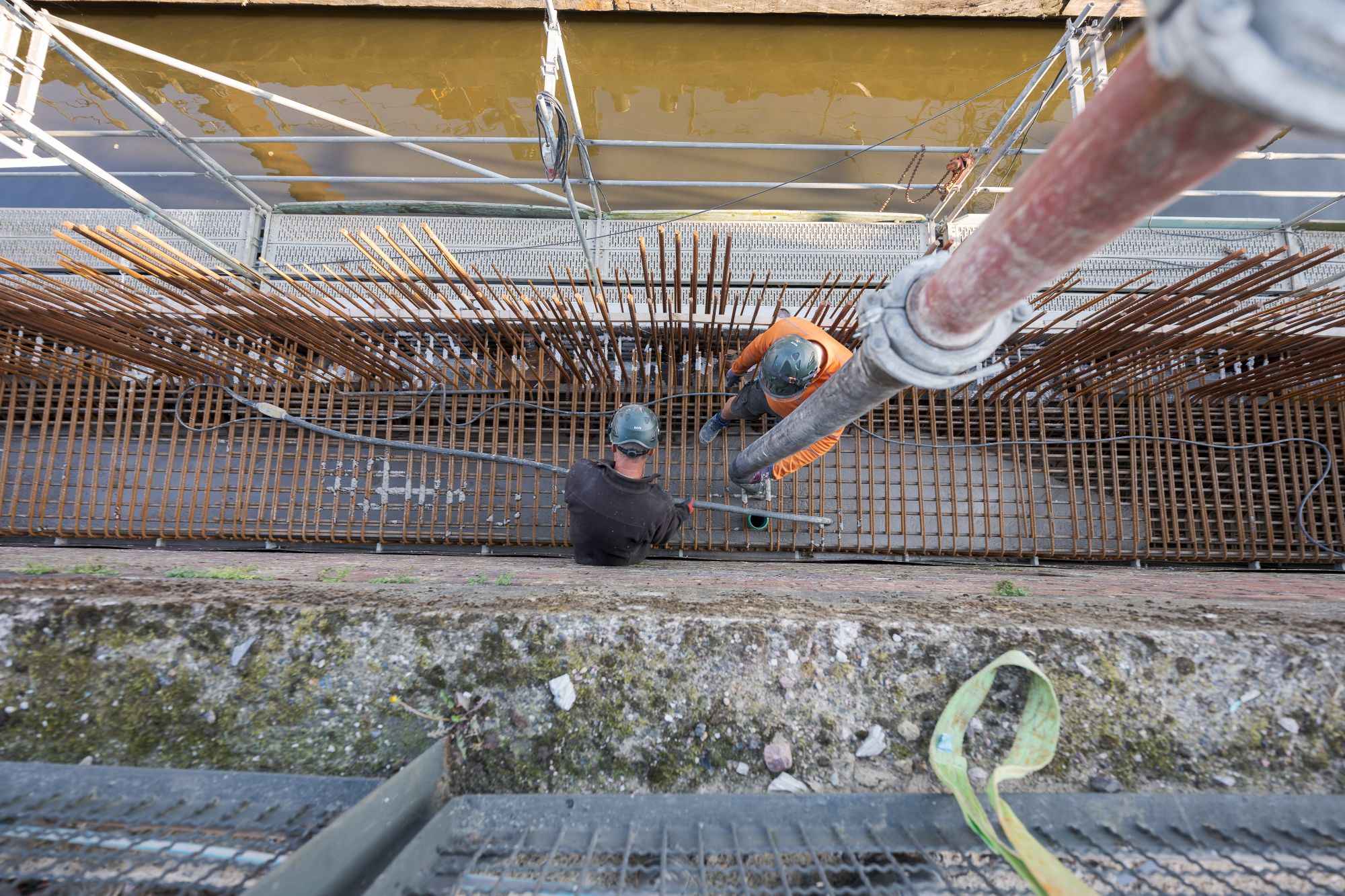 Bauarbeiter arbeiten an einer Bewehrungskonstruktion auf einer Baustelle am Kanal in Hamburg.