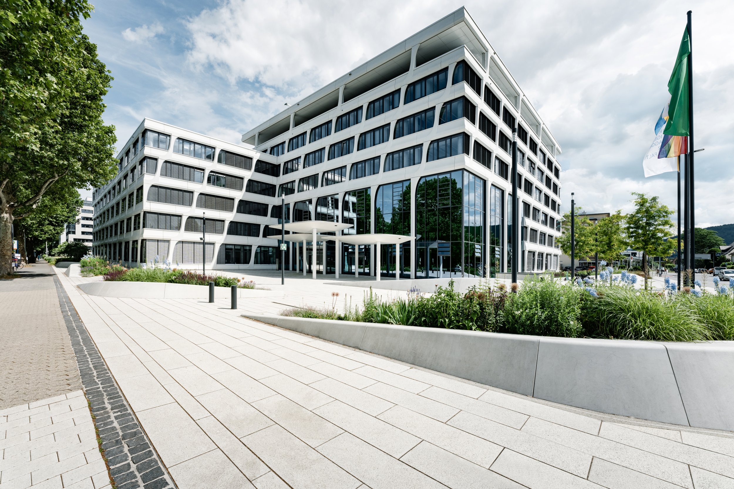 Hauptverwaltung von Heidelberg Materials mit klarer Glas- und Fassadenstruktur, umgeben von einer begrünten Außenanlage.