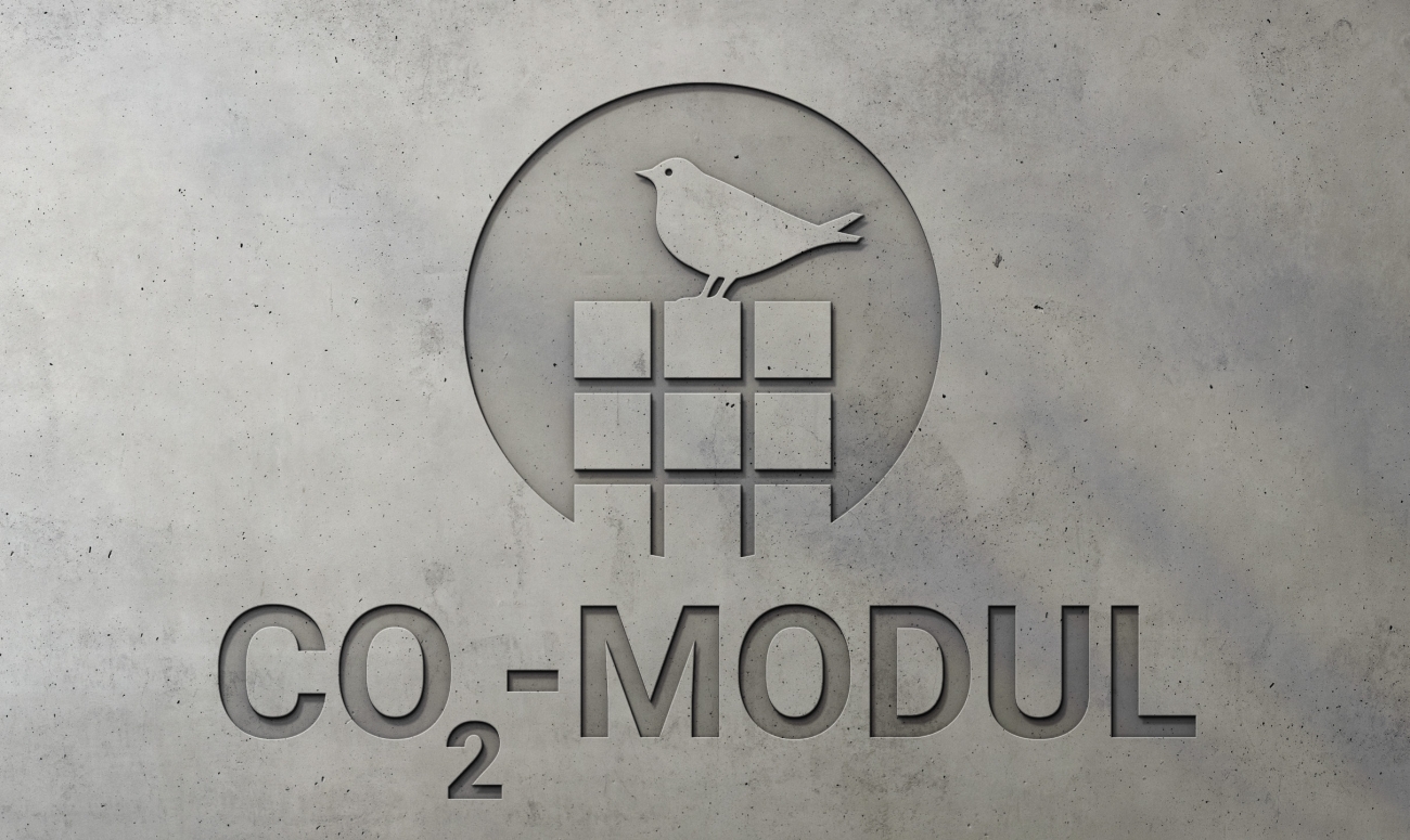 Logo des CO₂-Moduls mit Vogel und stilisierten Betonblöcken auf grauem Hintergrund.