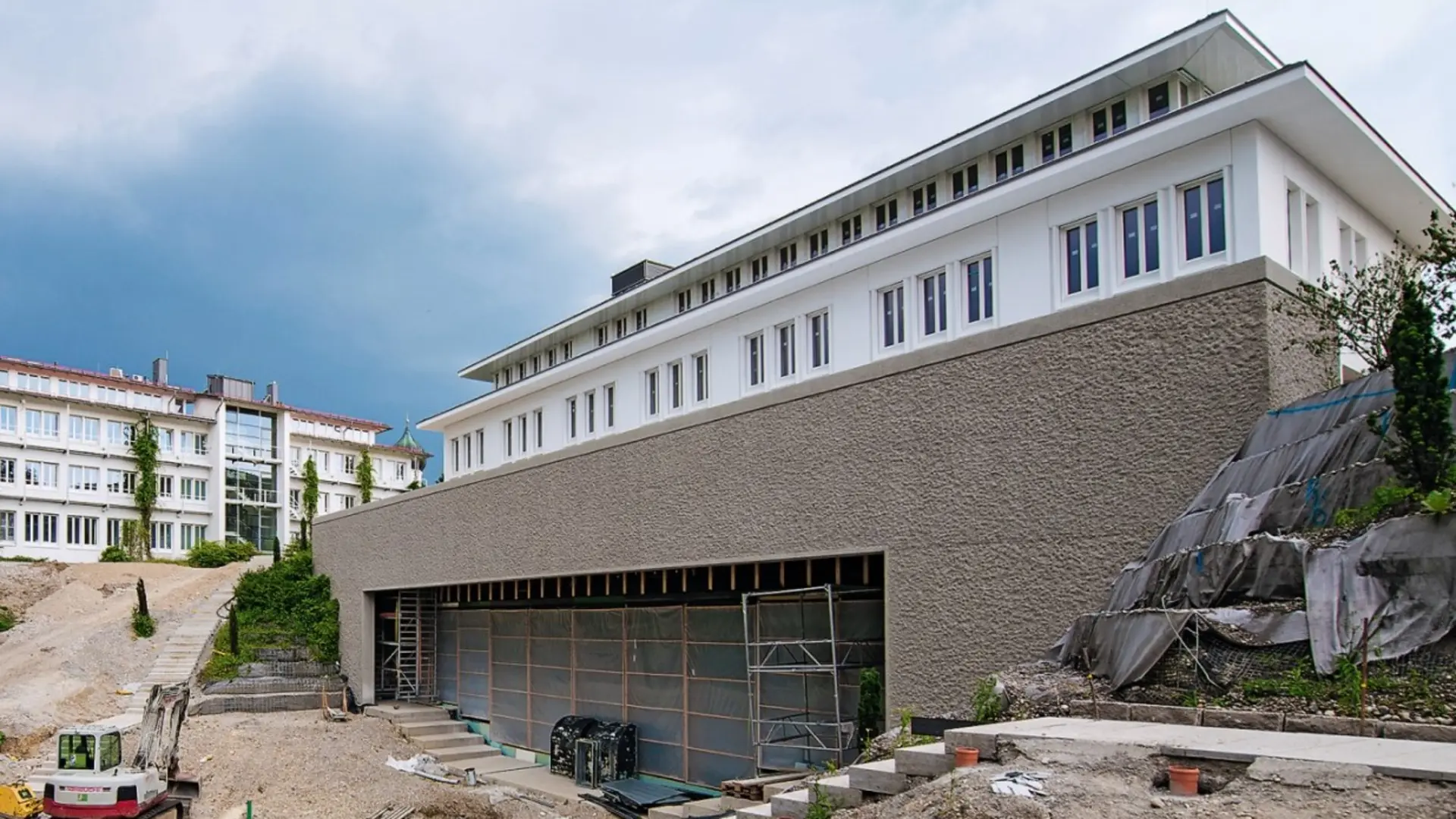 Bauvorhaben mit mehreren Gebäuden und einer Baustelle im Vordergrund.