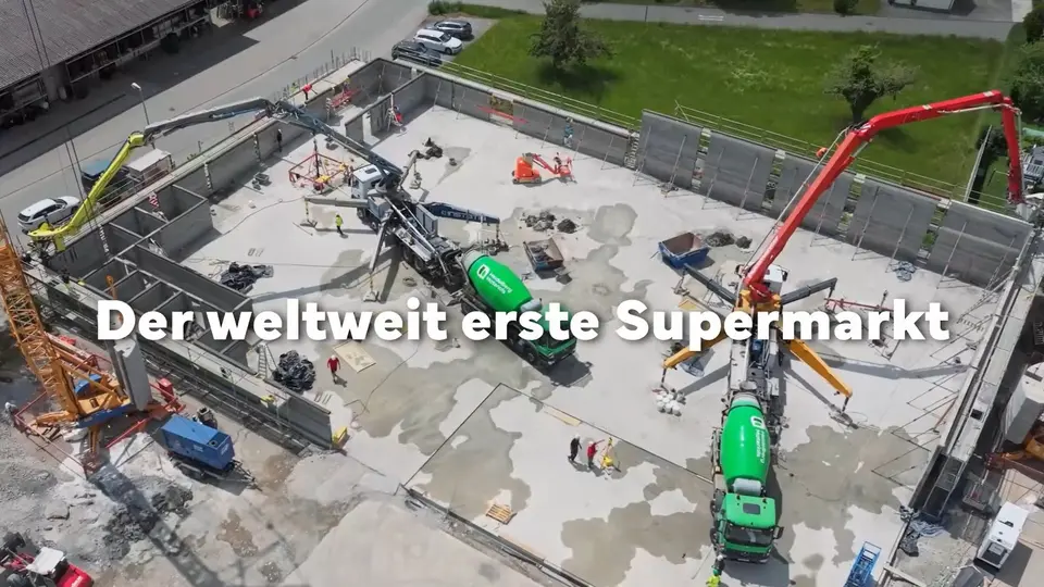 Baustelle mit Betonpumpen und Baukränen beim Bau eines Gebäudes.