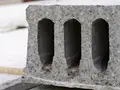Betonblock mit drei Hohlräumen liegt auf einer Baustelle.