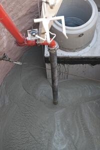 Beton wird über eine Rohrleitung in einen Schalungsbereich gegossen.