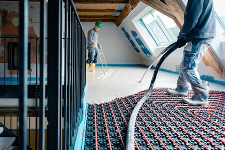 Einbau von einem sehr fließfähigen Calciumsulfat-Fließestrichs auf Fußbodenheizung.