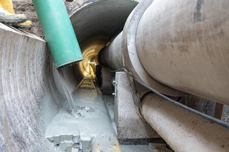 Füllmaterial Poriment umschließt alle Leitungen im Tunnel.