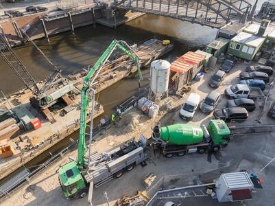 Baustelle mit Betonfahrmischer und Betonpumpe neben einem Kanal in der Speicherstadt.
