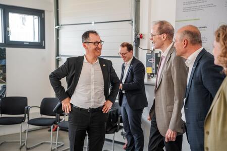 Mitarbeiter führen eine entspannte Unterhaltung in einem modernen Büro oder Besprechungsraum.