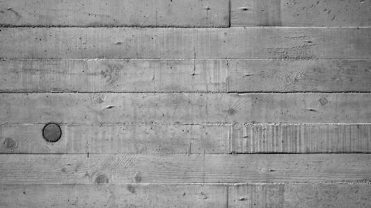 Betonoberfläche mit sichtbaren Holzmaserungen von Schalungsbrettern.