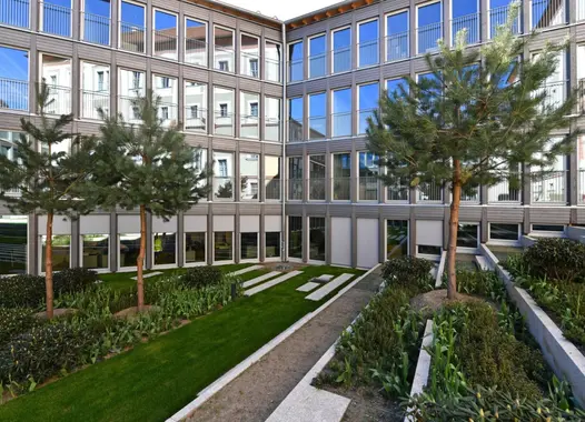 Bodentiefe Fenster bringen in alle Büroetagen Tageslicht. Von der Straßenseite aus betrachtet ist der Bau nur eingeschossig.